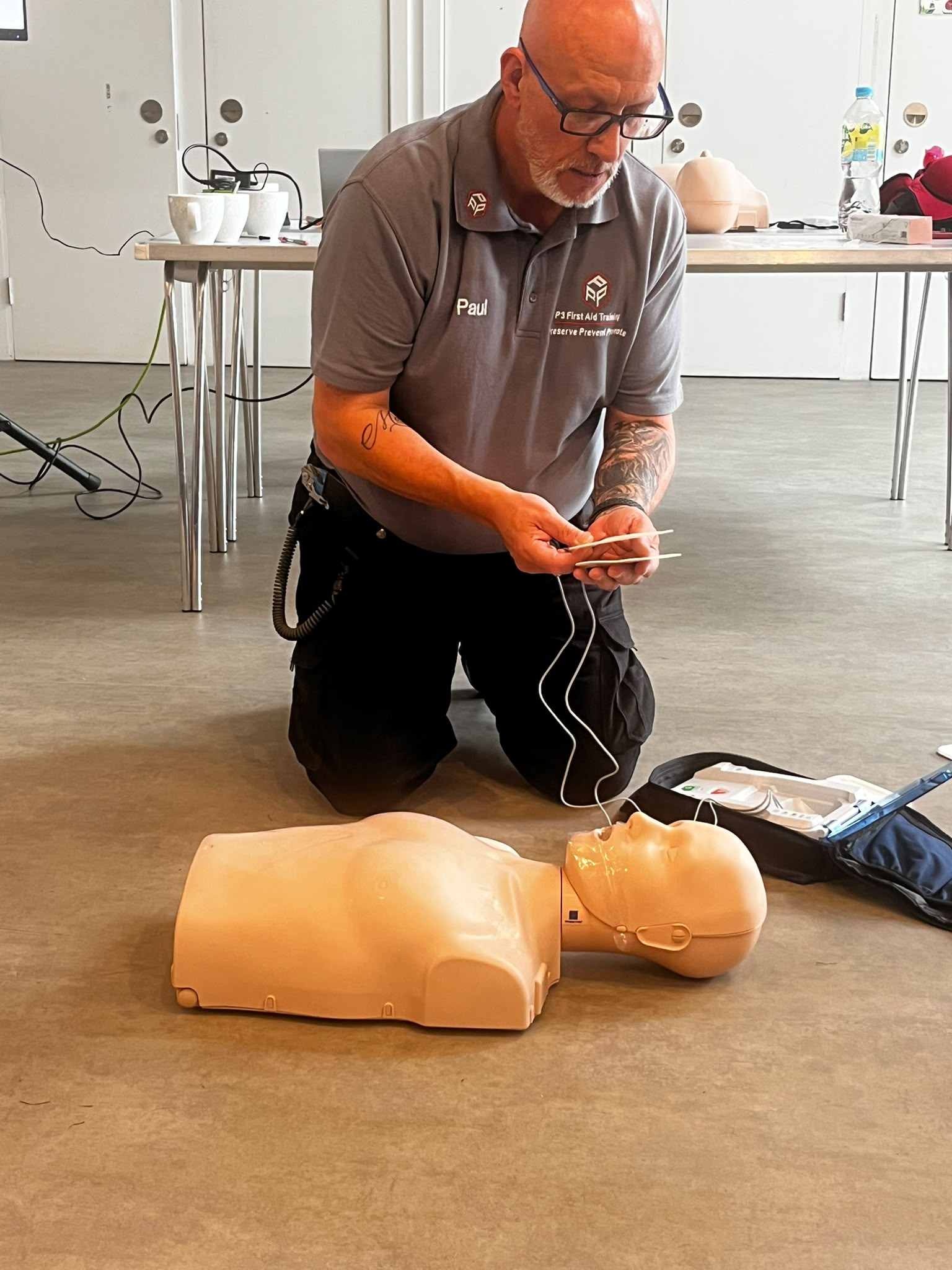 P3 First Aid Training instructor demonstrating AED use on a CPR manikin